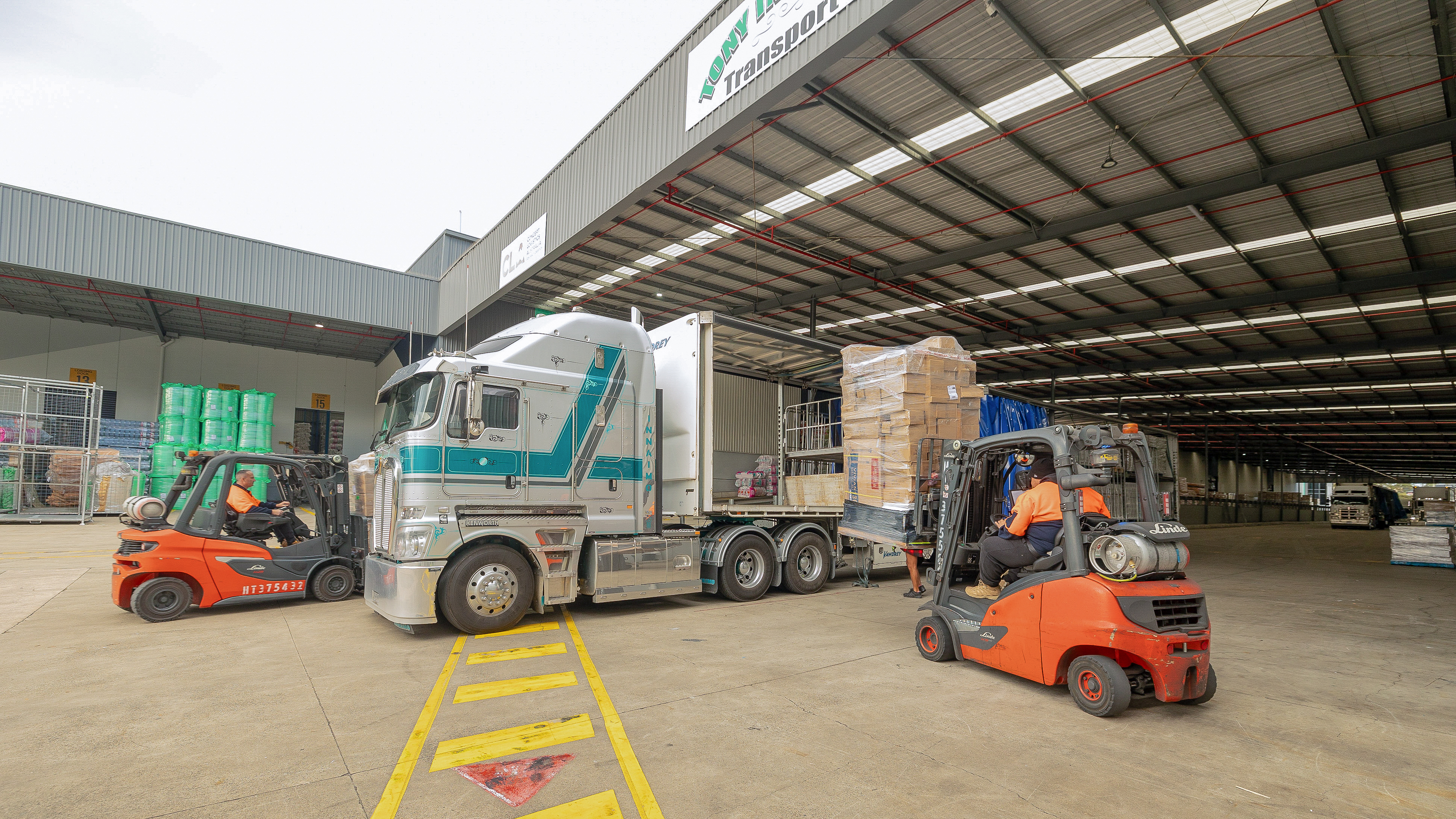 Red engine forklifts performing unloading operations at customer site