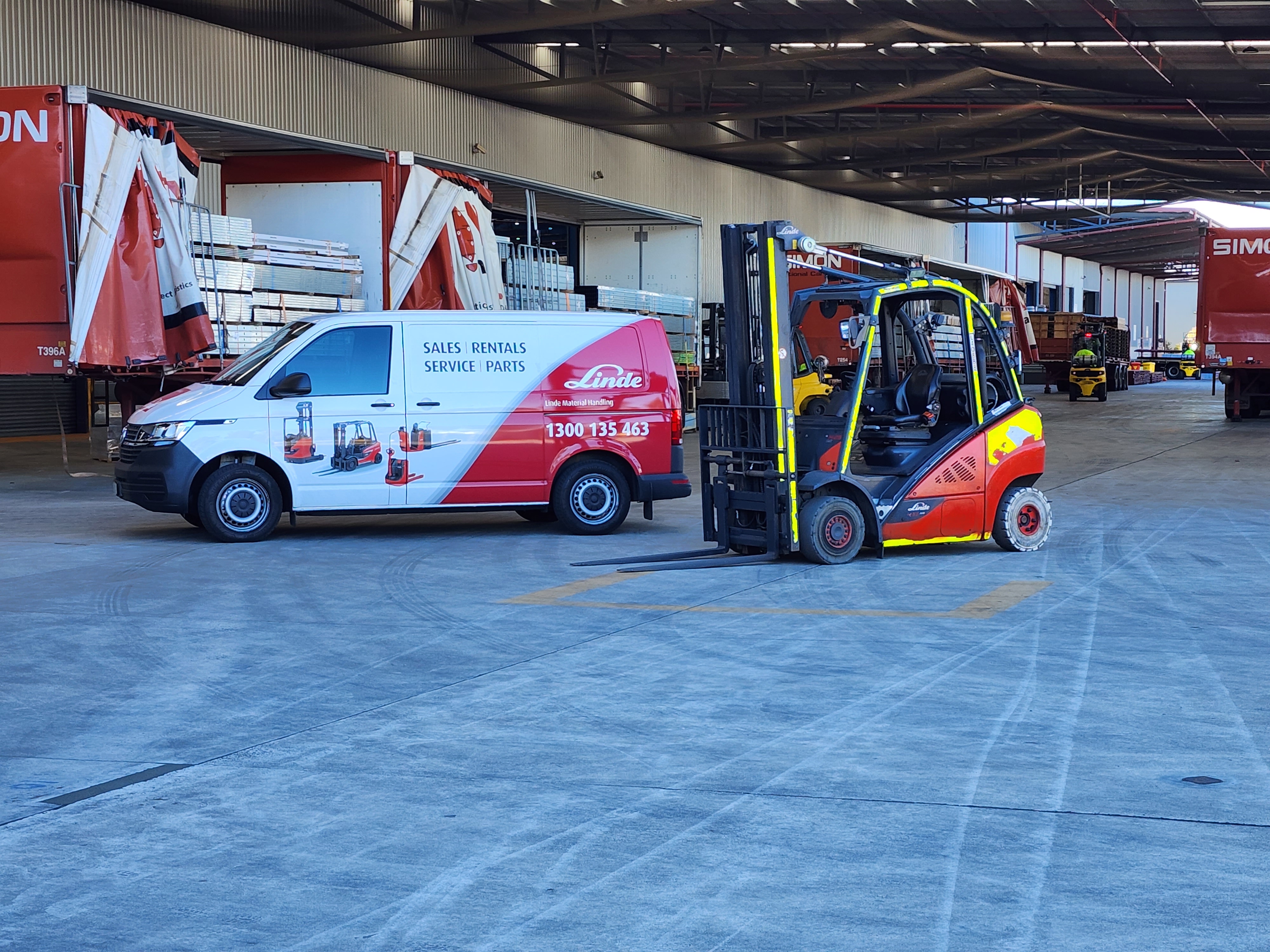 Used forklift in front of Linde van
