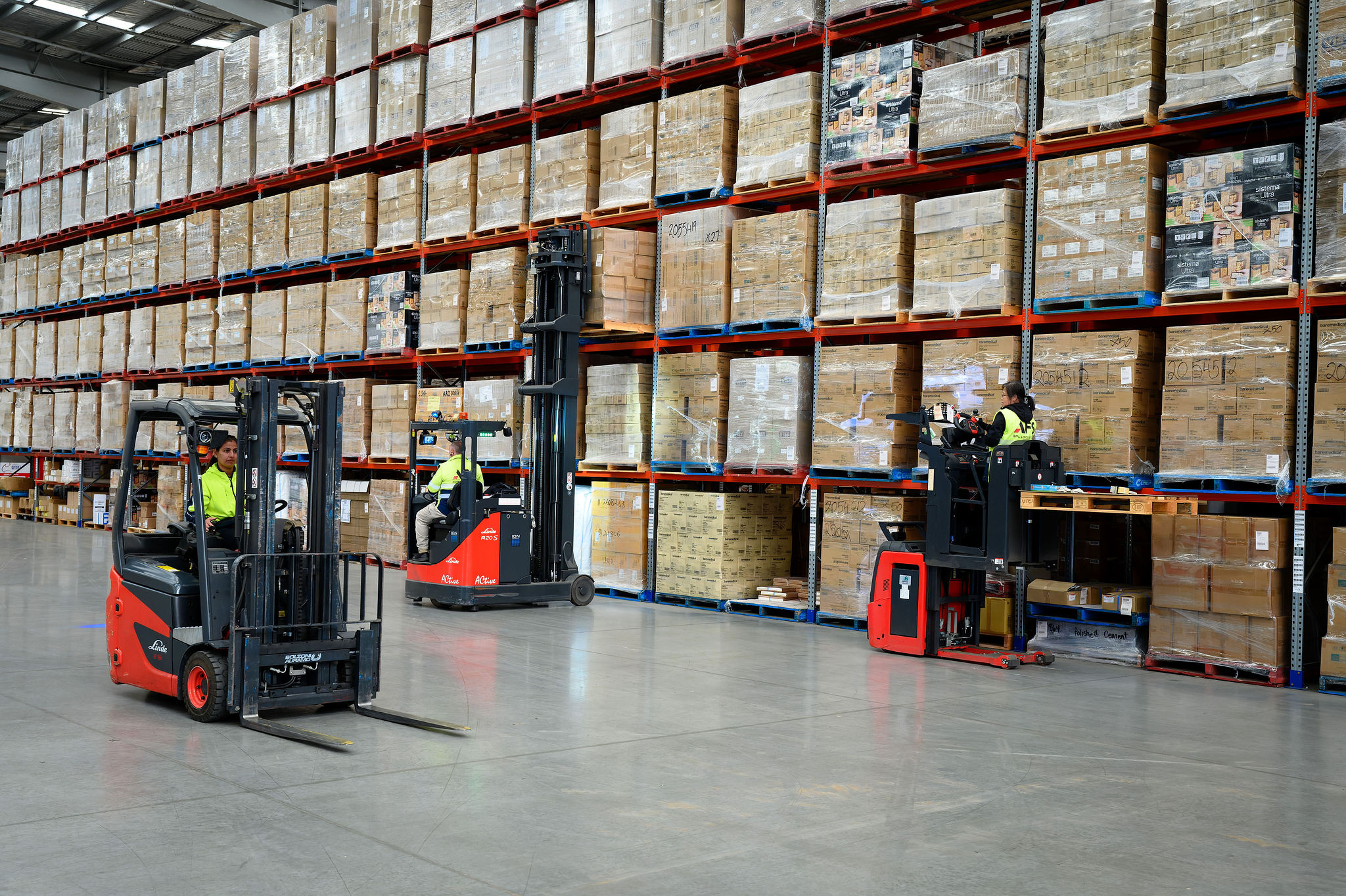 Red Linde forklifts and warehouse equipment busy with racking applications at AFS Logistics site