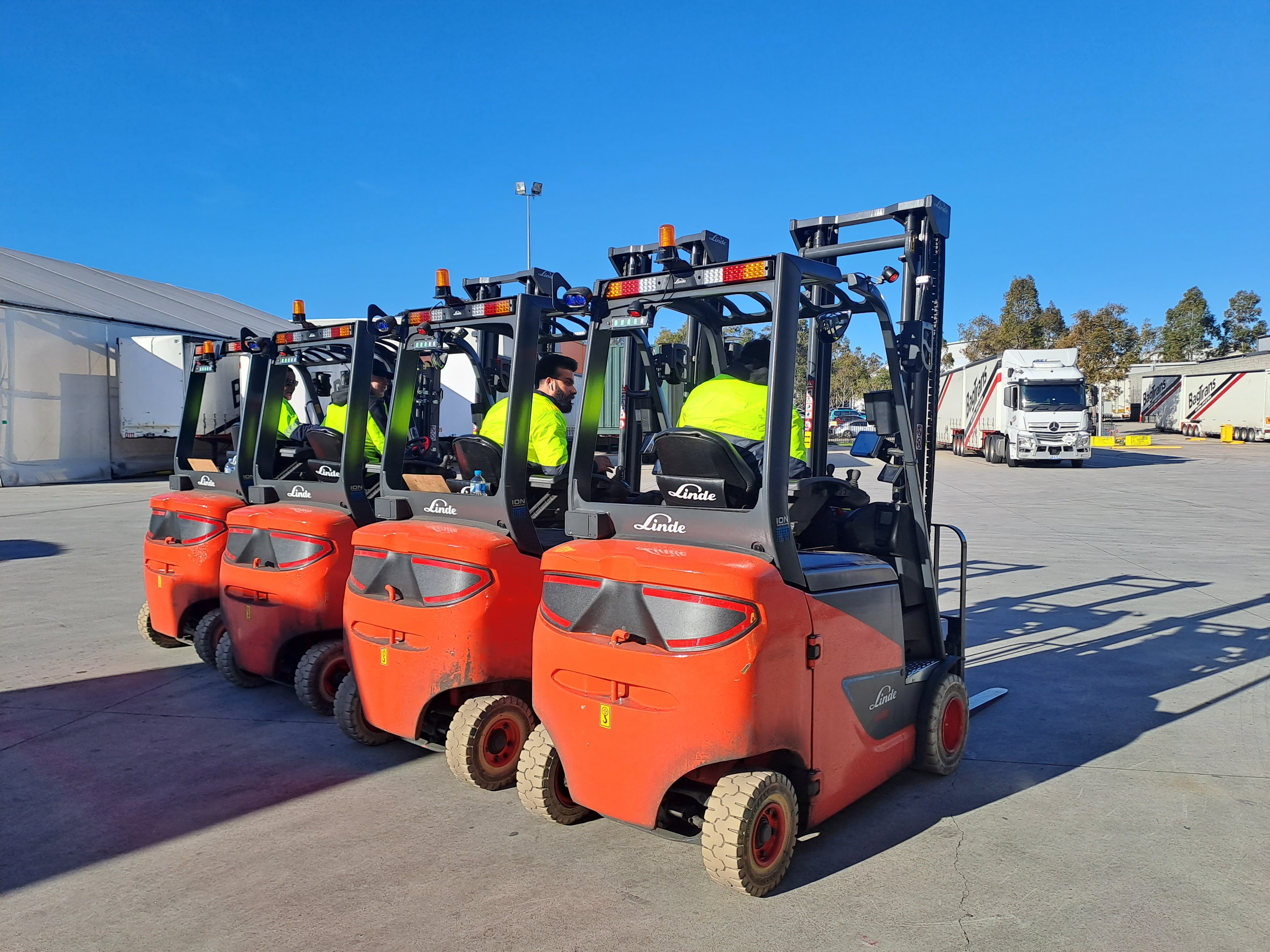 Back of four Linde electric forklifts 